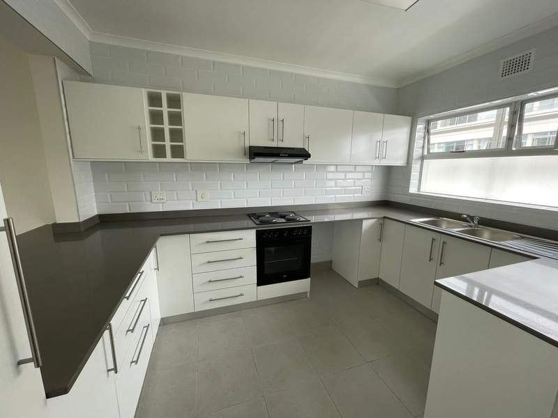 Modern kitchen with white cabinetry and subway tile